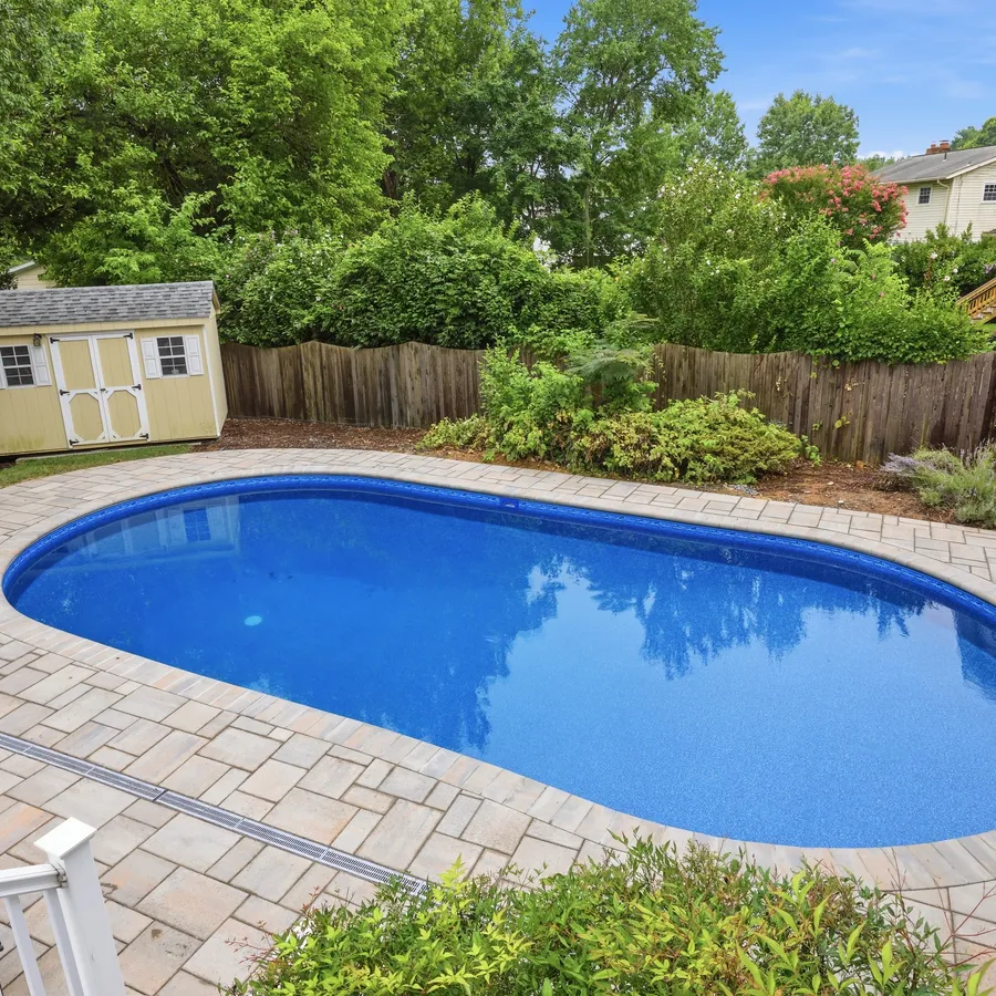 Renovated pool corner with new paver deck and freshly planted landscaping borders