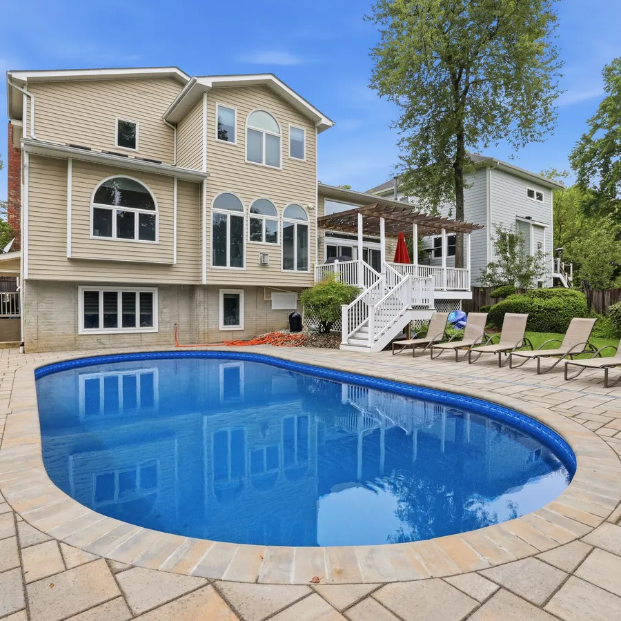 Completed Beltway Pools renovation: restored inground pool with a brand-new paver deck behind a DMV-area home
