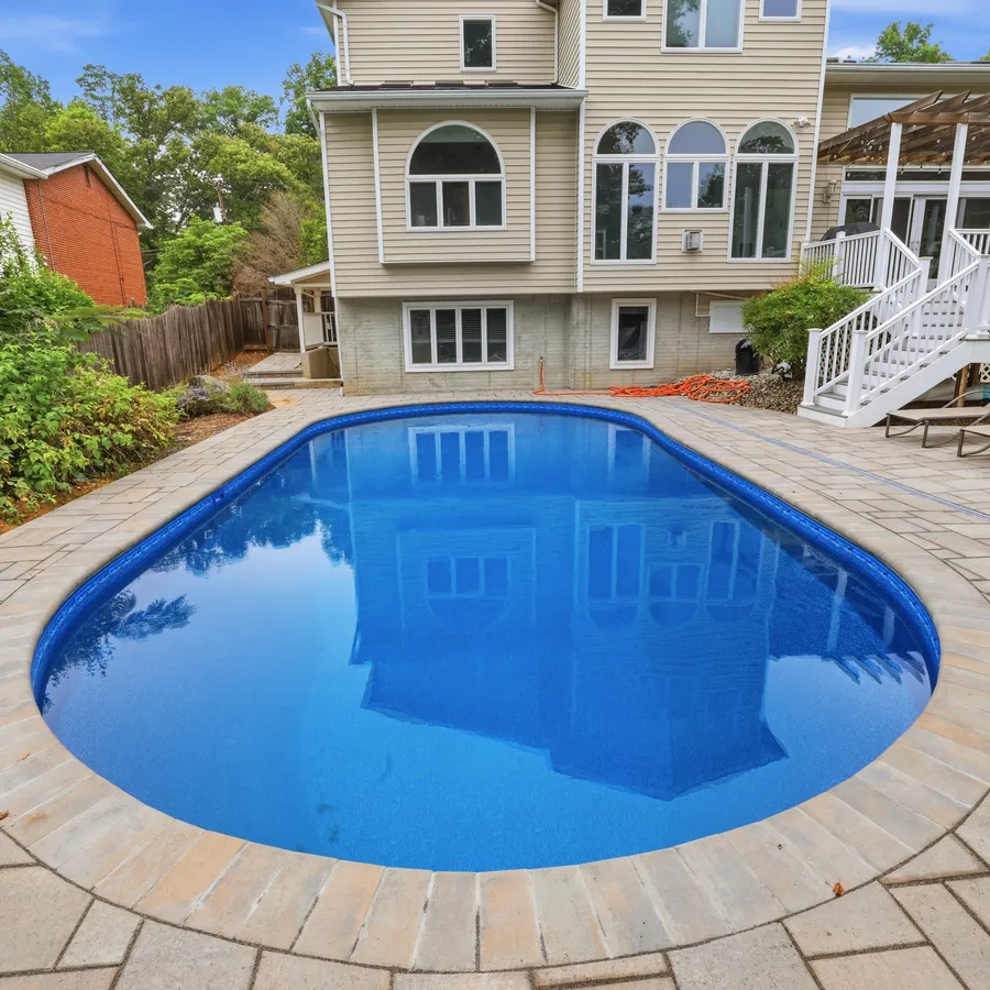 Renovated inground pool with new paver deck and coping, looking back toward the house