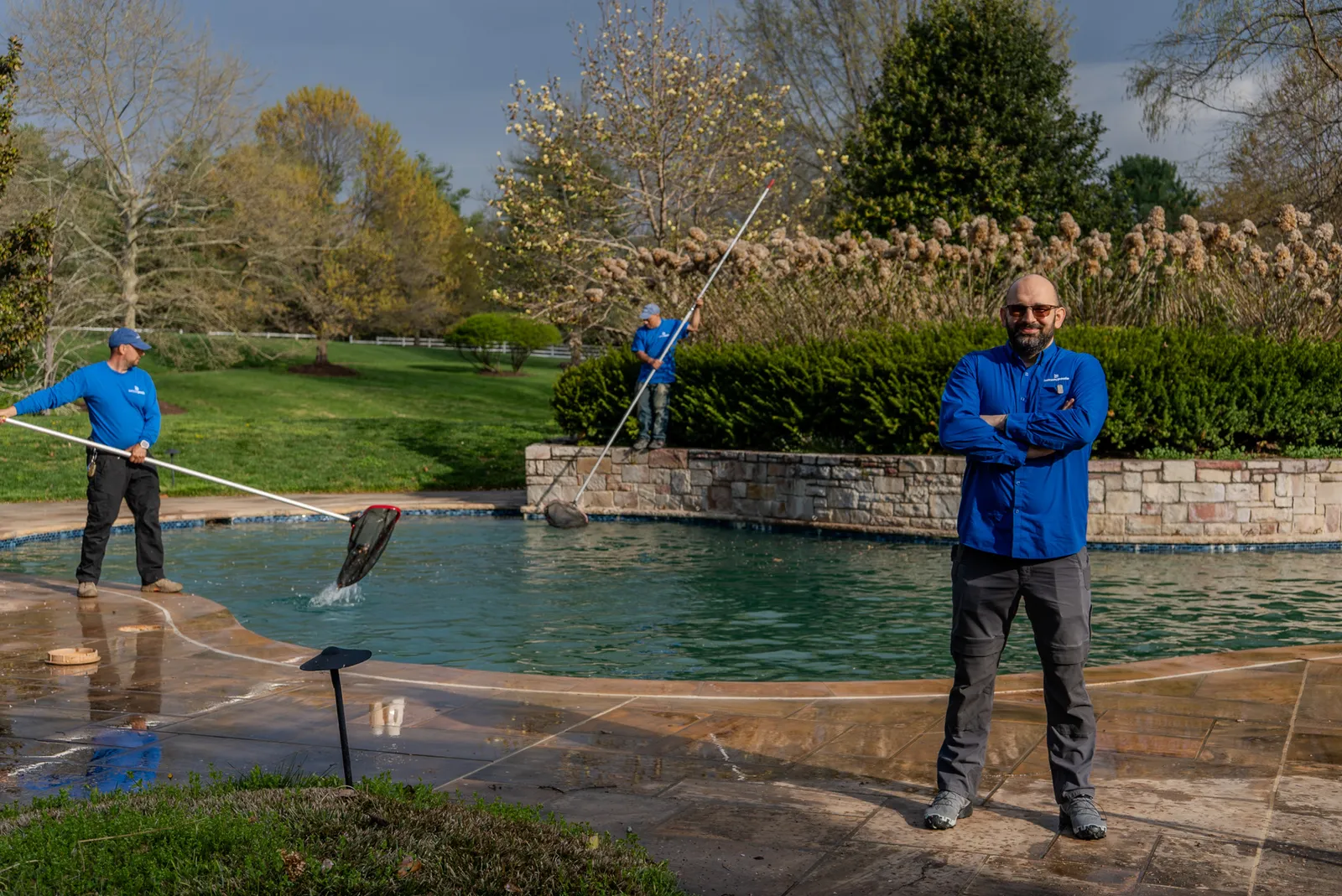 The Beltway Pools maintenance crew servicing a freeform pool on a weekly service visit